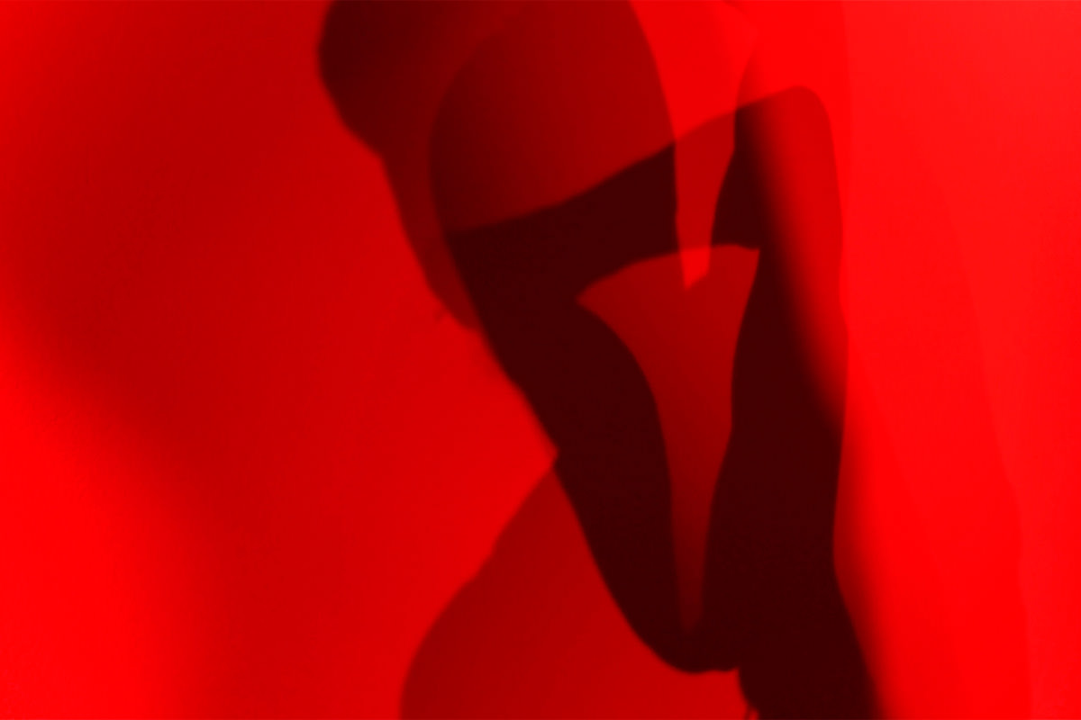 Rotes LIcht mit überscheneidenen Schatten eines Körpers